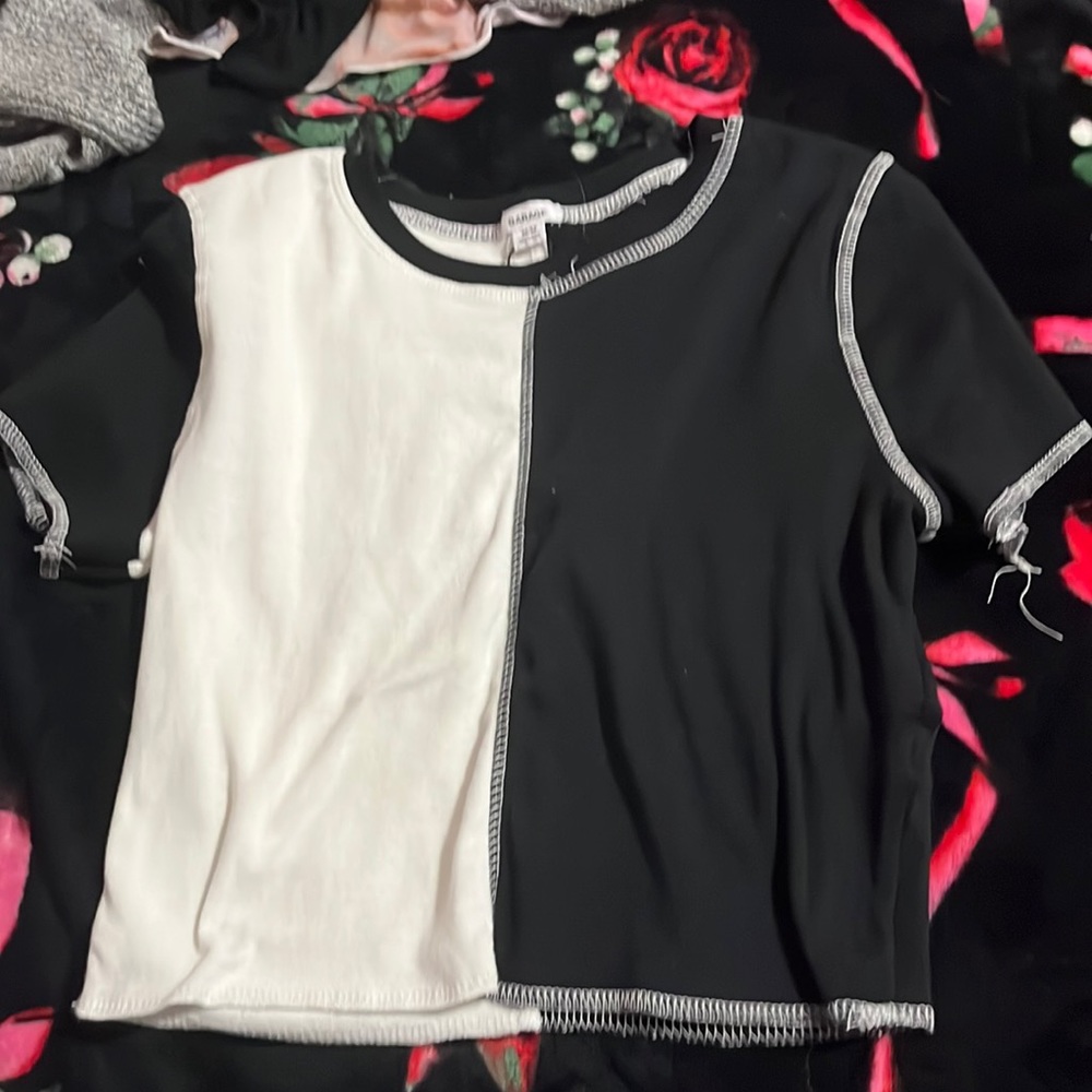 It is a white and black half color top and it is a short sleeve shirt.